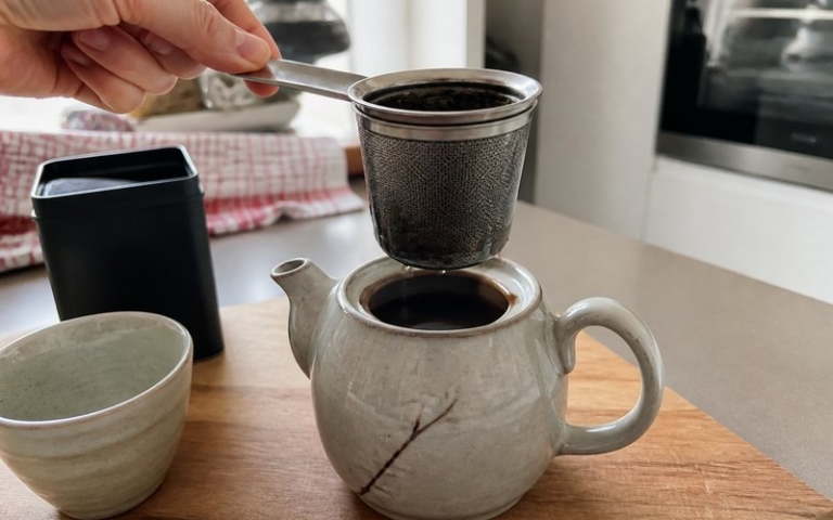 Dauerfilter mit Teeblättern in der Kanne